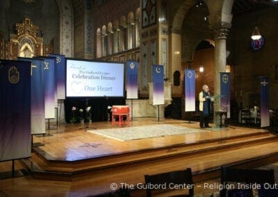 Banners on the stage represent the religious communities represented by Advisors to The Guibord Center, attending the One Heart Celebration Dinner
